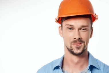 Mavi gömlekli erkek inşaatçı. Duyguları var. Profesyonel ışık arka planı.
