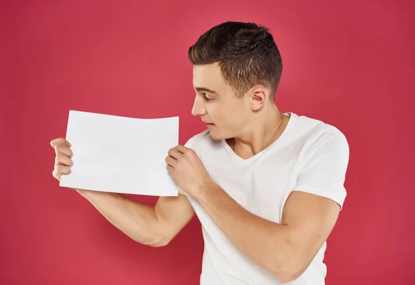 Man in a white t-shirt with a sheet of paper Copy Space — Stock Photo, Image