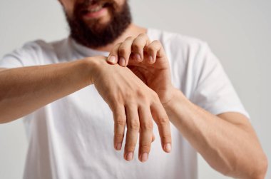 Beyaz tişörtlü adam el yaralanması sağlık sorunları eklem ağrısı