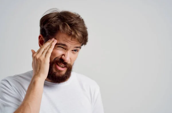 Uomo in una t-shirt bianca mal di testa problemi di emicrania Studio trattamento — Foto Stock