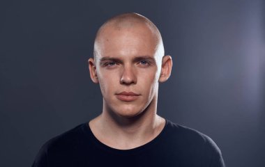 Siyah kazaklı kel kafalı neşeli bir adamın yakın çekimi.