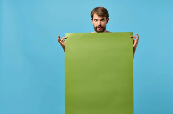 녹색 흉내 내기 포스터를 들고 있는 수염있는 남자외진 배경 할인 — 스톡 사진