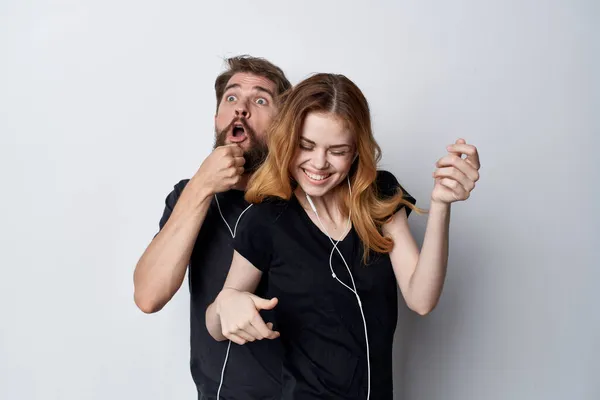 Веселая молодая пара в черных футболках телефон весело вместе дружба Студия стиль жизни — стоковое фото