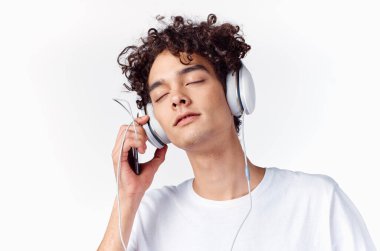 Kulaklık takan beyaz tişörtlü bir adam. Müzik tarzı.
