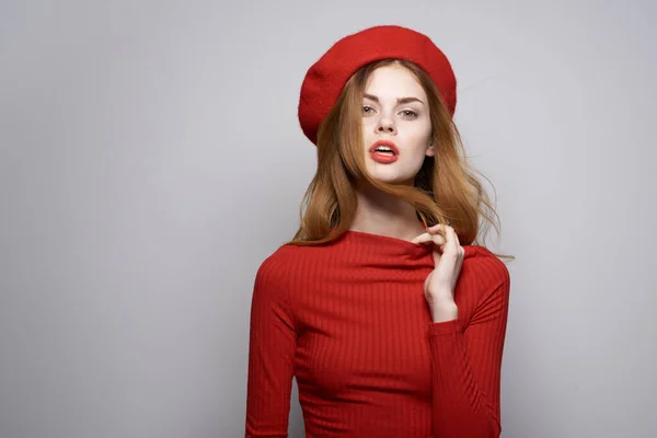 Bonita mulher com um boné vermelho em sua cabeça glamour estúdio posando — Fotografia de Stock