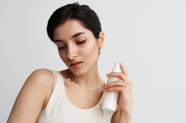 Beyaz atlet bluzlu güzel esmer krem nemlendirici cilt bakımı