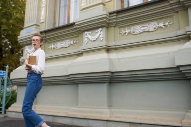 Caddedeki kısa saçlı kadın. Binanın yanında dinlenme eğitimi alıyor.