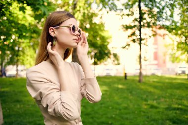 Güzel bir kadın güneş gözlüğü ve yeşil çimen modelinde bir şapka.