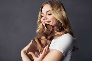 Güzel bir kadın. Küçük bir köpek eğlencesi. Stüdyo izole edilmiş.