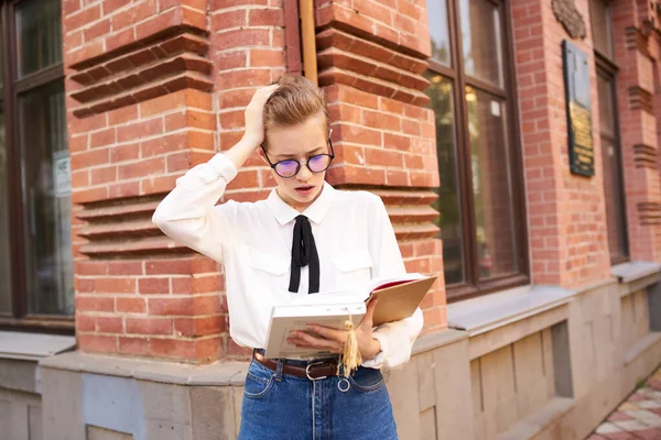 Pretty woman with glasses walking around the city with a book education — Stock Photo, Image