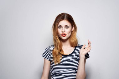 Güzel bir kadın elinde saç makyajı ile komik moda ifadesi sergiliyor.