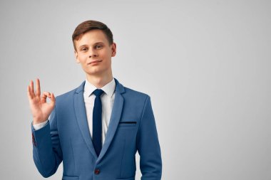 Takım elbiseli bir iş adamı, el kol hareketleriyle profesyonel bir iş yapıyor.