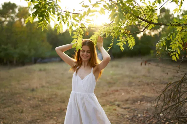 Yazın açık arazide beyaz elbiseli neşeli bir kadın. — Stok fotoğraf