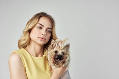 Sarı elbiseli güzel bir kadın. Eğlenceli. Küçük bir köpek manzaralı.