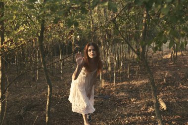 Beyaz elbiseli kadın yaz mevsiminde temiz hava alır.