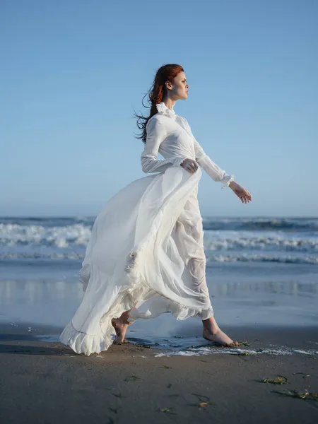 Γυναίκα σε λευκό φόρεμα σε εξωτερικούς χώρους παραλία με τα πόδια ωκεανό — Φωτογραφία Αρχείου