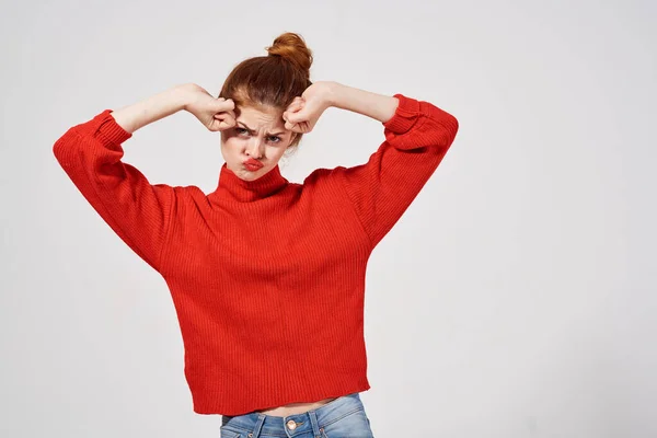 Pretty woman in a red sweater light background — Stock Photo, Image