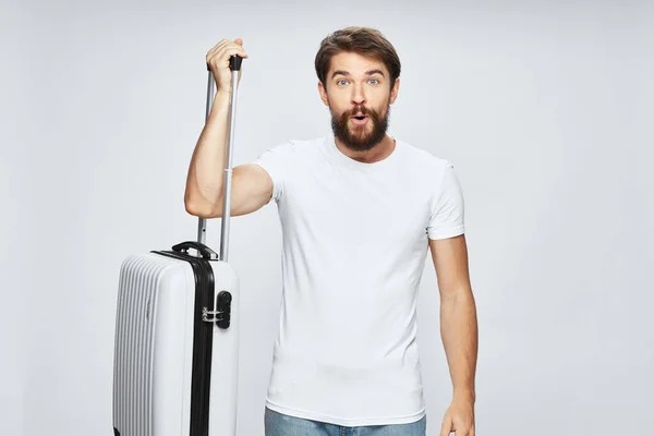 Hombre de viaje con maleta blanca sobre fondo claro recortado ver modelo de turismo —  Fotos de Stock