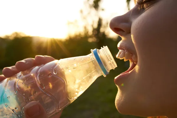 Csinos nő ivóvíz egy üveg nyári szomjúság — Stock Fotó