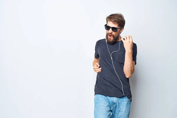 Knappe man koptelefoon zonnebril muziek dans leuk geïsoleerde achtergrond — Stockfoto