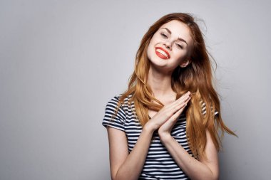 Güzel bir kadın elinde saç makyajı ile komik bir moda ifadesi takınıyor.