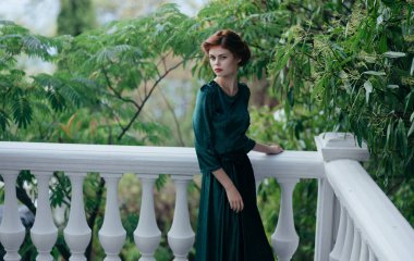 Yeşil elbiseli kadın moda mimarisi ile yürüyor.