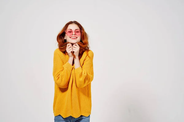 Vacker kvinna i en gul tröja frisyr mode glasögon ljus bakgrund — Stockfoto