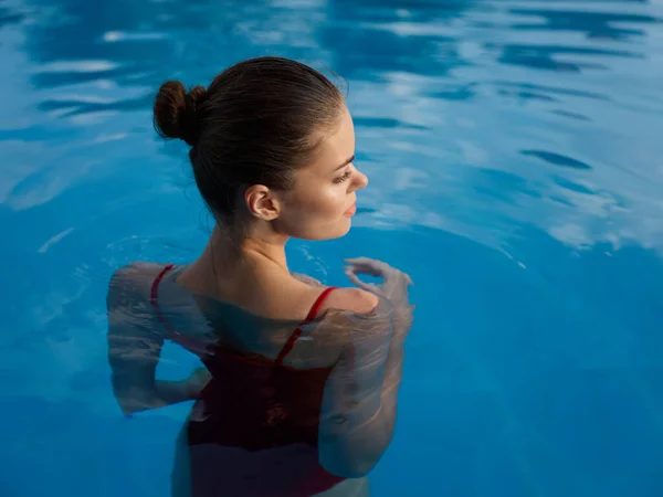 Mujer en traje de baño rojo en la piscina naturaleza vista trasera lujo ocio —  Fotos de Stock