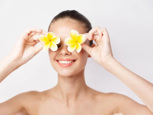 Mujer con hombros desnudos flores amarillas cerca de los ojos de cerca — Foto de Stock