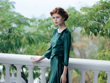 Yeşil elbiseli kadın moda mimarisi ile yürüyor.