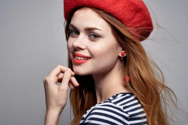 Mujer alegre en una camiseta rayada labios rojos gesto con sus manos aire fresco —  Fotos de Stock