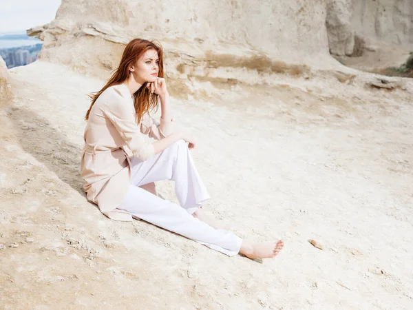 Bonita mujer posando cerca de rocas en la arena estilo de vida de moda — Foto de Stock