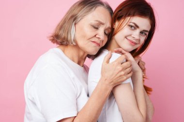 Büyükanne ve torunun yakın iletişimi pembe arka planı severler.