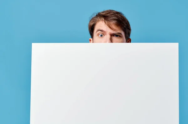 Knappe man witte lakens presentatie reclame blauwe achtergrond — Stockfoto