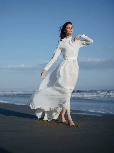 Γυναίκα σε λευκό φόρεμα με τα πόδια κατά μήκος της παραλίας διακοπές ωκεανό — Φωτογραφία Αρχείου