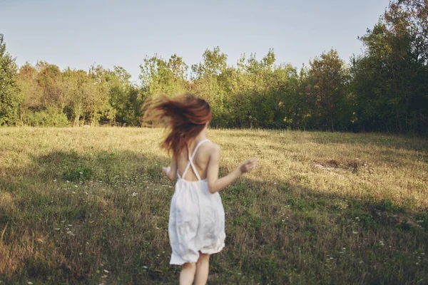 Vrouw in witte jurk lopen in het veld rust greens — Stockfoto