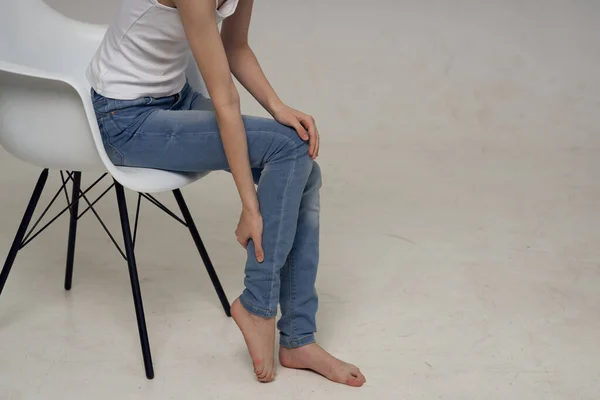 Mulher Sentada Uma Cadeira Com Dor Nas Pernas — Fotografia de Stock