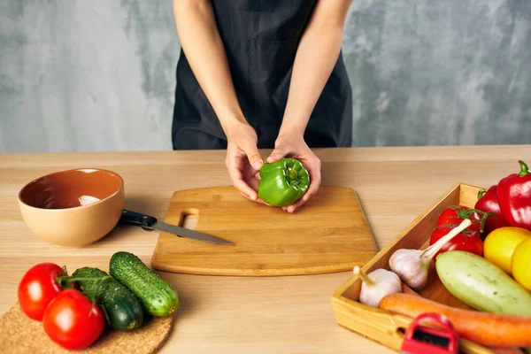 Cocinar mujer en la cocina cortar verduras —  Fotos de Stock