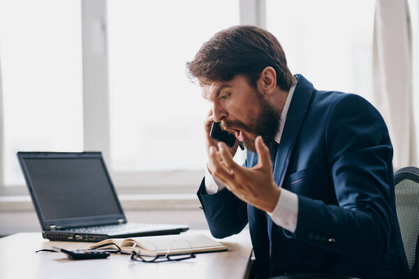 businessman sitting at a desk in front of a laptop,  stress 