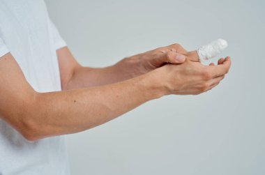 Üzerinde bandajlı hastane ilacı olan beyaz tişörtlü bir erkek hasta.