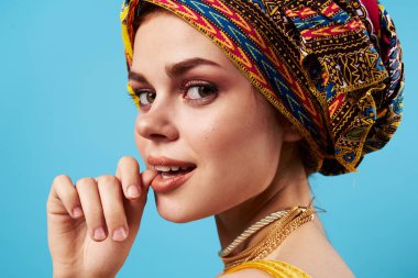 Çok renkli türbanlı neşeli kadın. Çekici görünüşlü. Mücevher tebessümü.