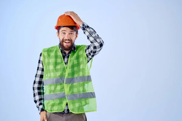 Эмоциональный человек зеленый жилет оранжевый шлем рабочий процесс жесты изолированный фон — стоковое фото