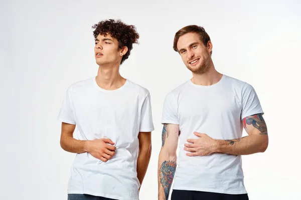 Due uomini in t-shirt amicizia comunicazione luce sfondo — Foto Stock