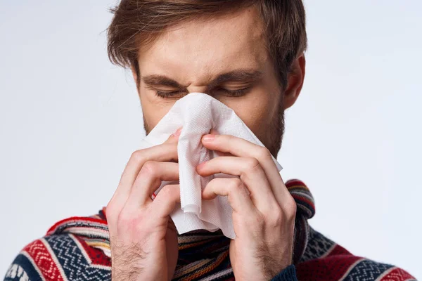Nemocný muž s kapesníkem zdravotní problém chřipka příznaky světlo pozadí — Stock fotografie