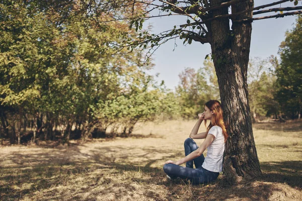 Vacker kvinna sitter nära ett träd Sun frihet resa — Stockfoto