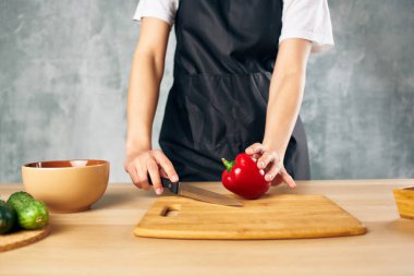 Siyah önlüklü kadın sağlıklı yemek pişiriyor.