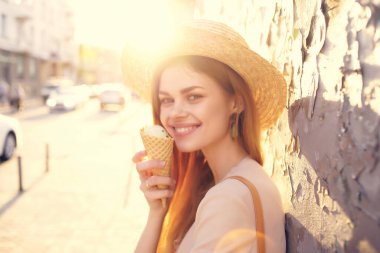 Güzel kadın dışarıda yürüyor dondurma yiyor, geziyor, eğleniyor.