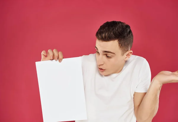 Man in een wit t-shirt met een vel papier Copy Space — Stockfoto
