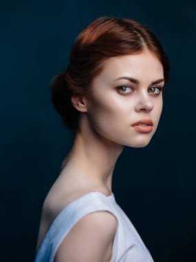 Beyaz elbiseli kızıl saçlı kadın. Çekici bir stüdyo görüntüsü var.