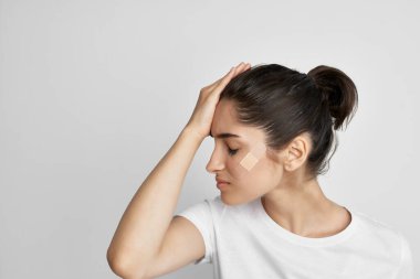 Hafif arka planda kafa travması geçiren bir kadın. Yüksek kalite fotoğraf